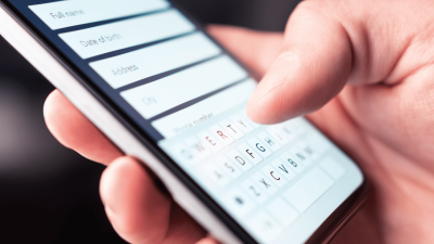 Close up shot of someone holding their phone and filingl out a form