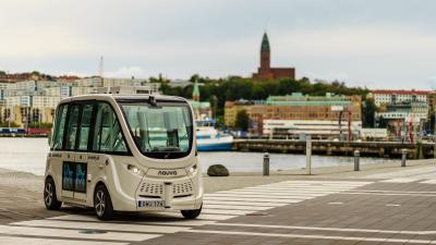 A white self-driving car in a city.
