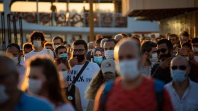 Busy public space where most people can be seen wearing a face mask
