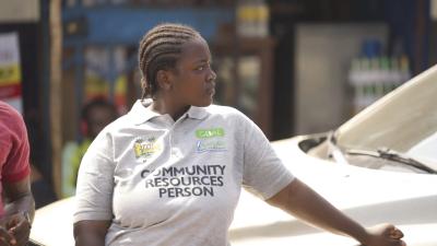 A community resources person standing in front of a car in Sierra Leone