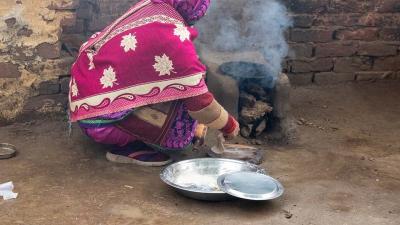 A woman cooking a flatbread on an open fire
