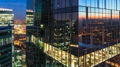 A city skyline at night, with several skyscapers shown in the foreground.