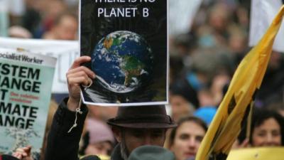 Banner image of people holding up signs in protest
