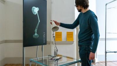 A person holding the lamp head of the object.