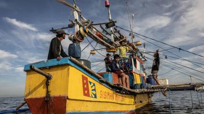 A group of fishers on a yellow fishing boat.