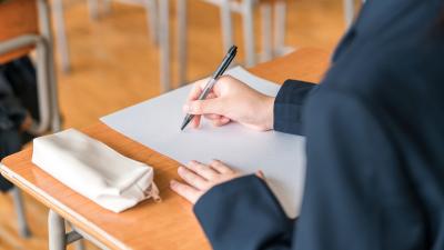 School child writing on paper