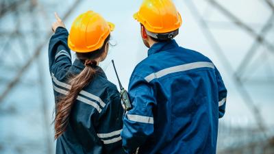 Two workers in uniform pointing and discussing