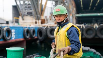 A deckhand on a tugboat at a commercial dock