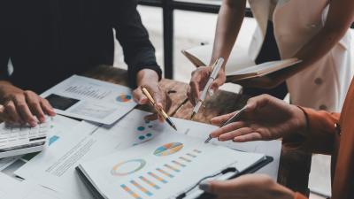 Business team analysing financial data using graphs, charts and calculator during a working meeting
