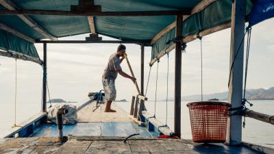 male fishermen stand on small boat