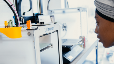 Student looking into a 3D printer 