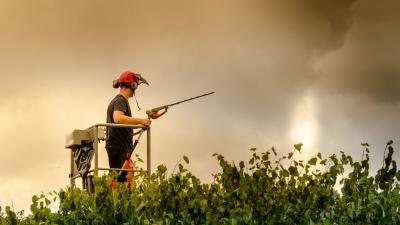 Worker using electrical tool in cloudy, storm-like weather