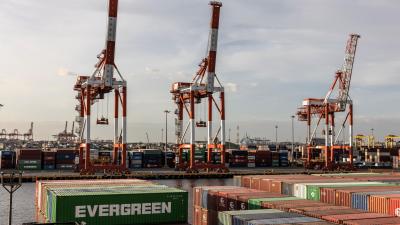 Shipping port with large container cranes and stacked shipping containers