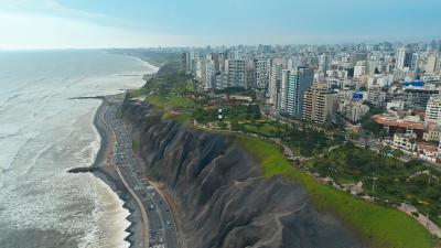 Aerial view of Lima, Peru coastline with dramatic cliffs, urban skyline and Pacific Ocean.