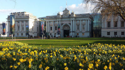 National Maritime Museum with blooming yellow daffodils in the foreground on a sunny day.