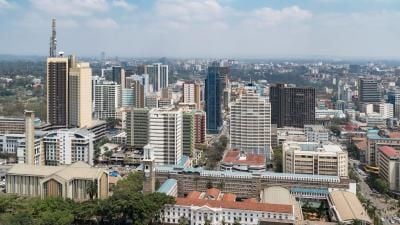 Aerial view of Nairobi city skyline with modern skyscrapers and historic buildings under blue sky.