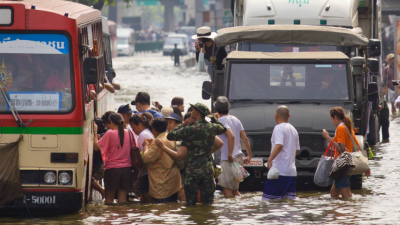 A photo of a huge flood disaster in Thailand, people can be seen walking through a flooded street.