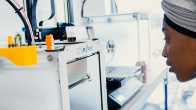 Student looking into a 3D printer 